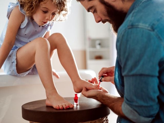 Father applying daughter's nail polish