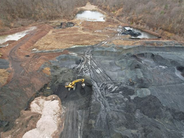 An excavator prepares waste coal materials to be transported from a site to the Scrubgrass Power Plant in Kennerdell, Pennsylvania