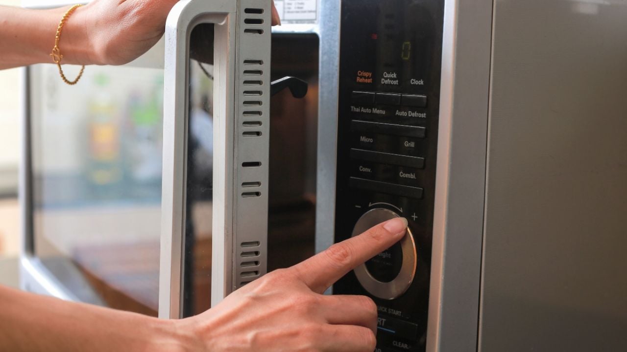 Person turning on microwave oven